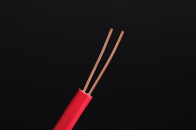 Photo of Red stripped electrical wire on black background, closeup