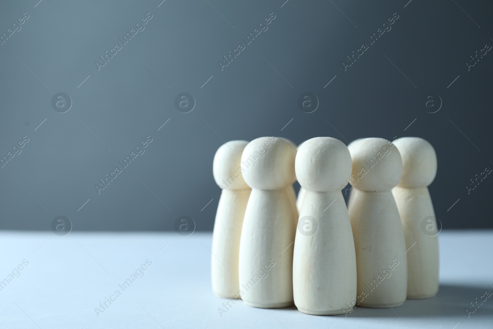 Photo of Human resources concept. Many wooden figures on table against grey background, closeup. Space for text