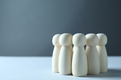 Photo of Human resources concept. Many wooden figures on table against grey background, closeup. Space for text