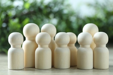 Photo of Human resources concept. Many wooden figures on table against blurred background, closeup