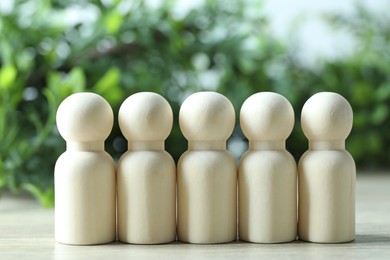 Photo of Human resources concept. Many wooden figures on table against blurred background, closeup