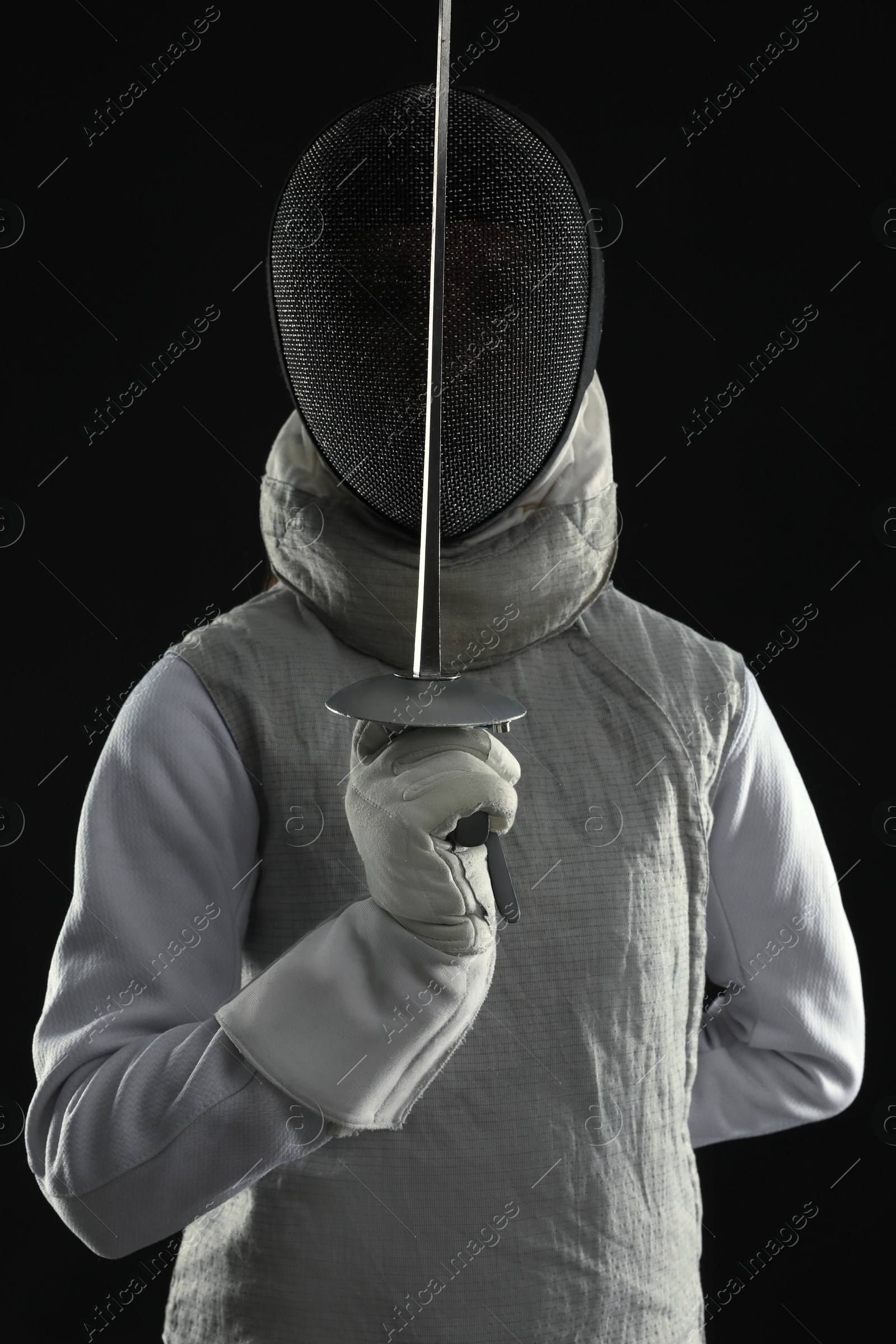 Photo of Fencer with epee on black background. Combat sport