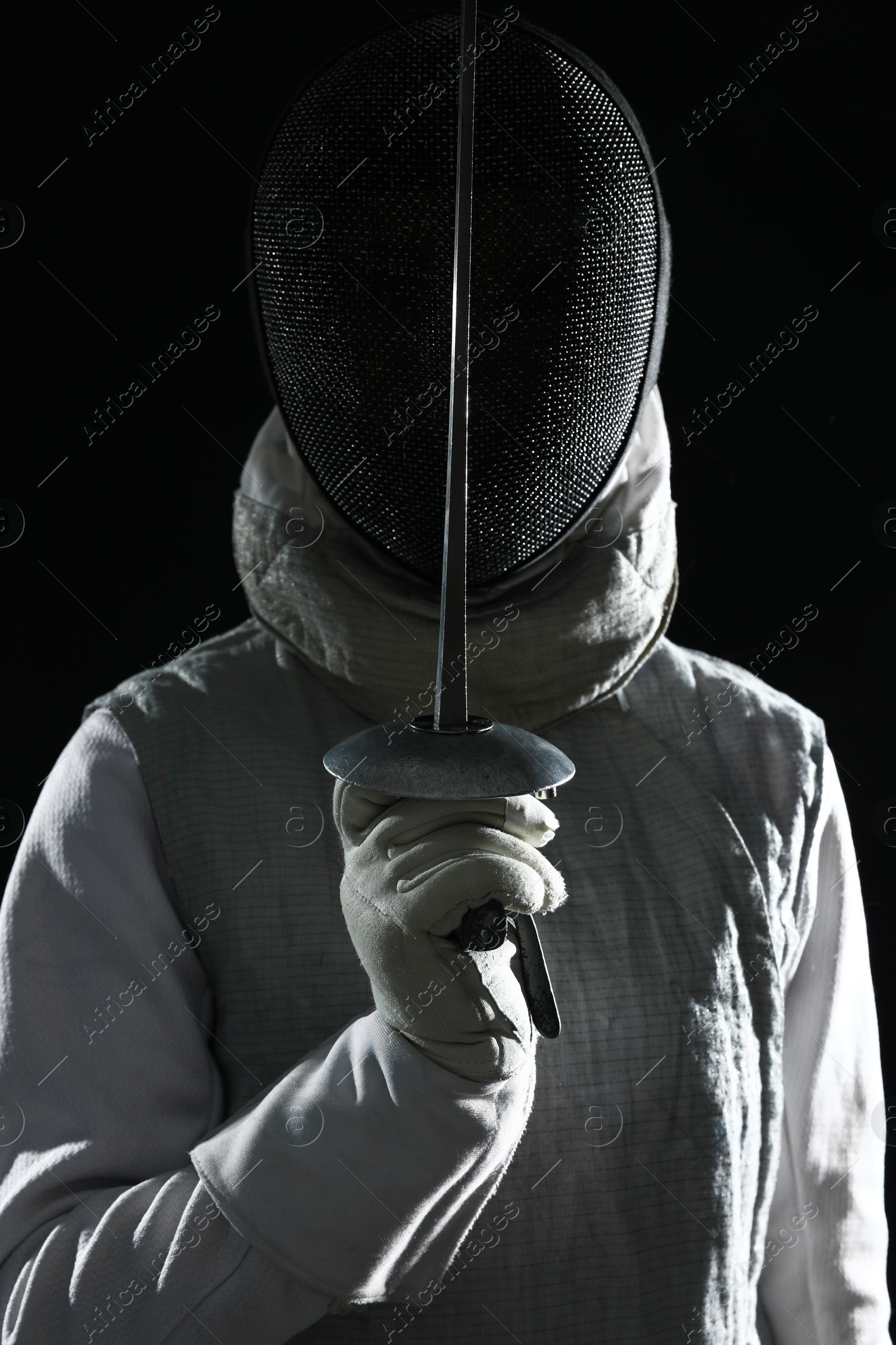 Photo of Fencer with epee on black background. Combat sport