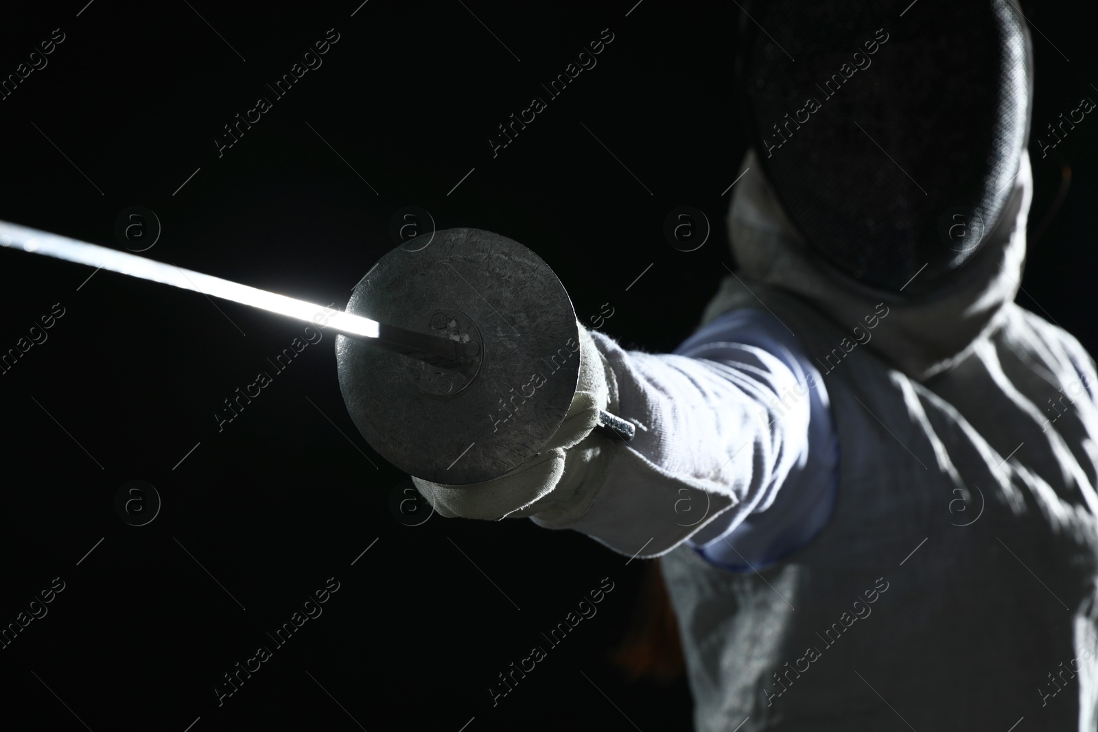 Photo of Fencer with epee on black background, selective focus