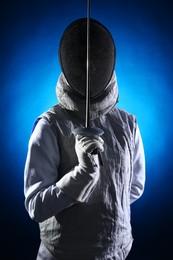 Fencer with epee on dark blue background