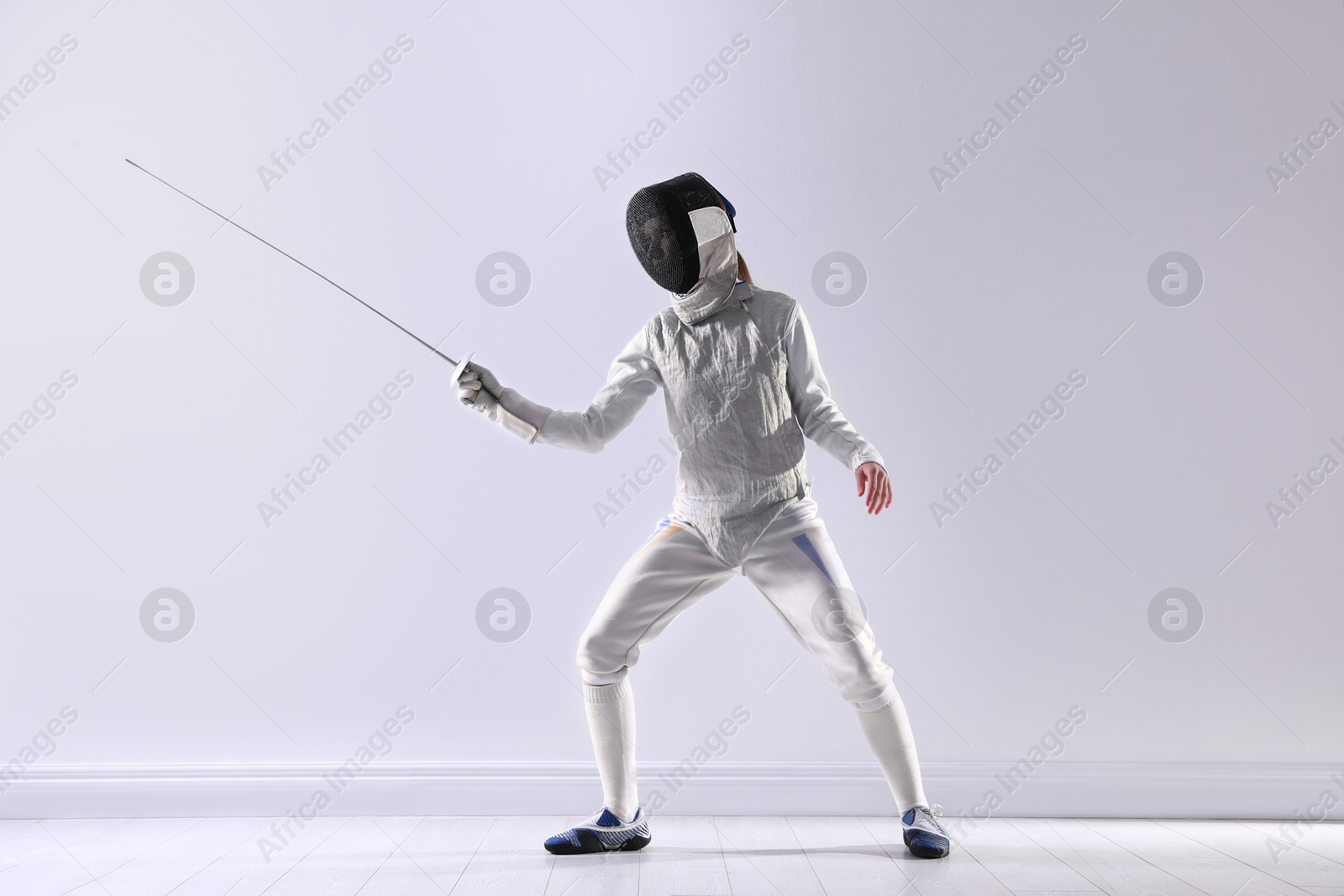 Photo of Fencer with epee practicing indoors. Combat sport