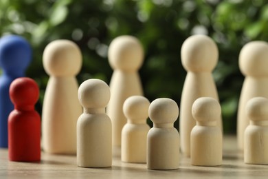 Photo of Human resources concept. Many wooden figures on table against blurred background, closeup