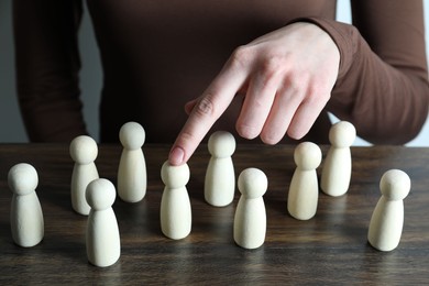 Photo of Human resources concept. Woman pointing at wooden piece among other ones at table, closeup