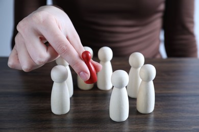 Photo of Human resources concept. Woman choosing red piece between other ones at table, closeup