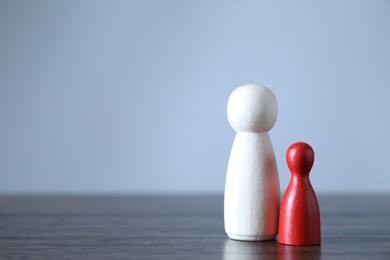 Photo of Human resources concept. Red and wooden figures on table, closeup. Space for text