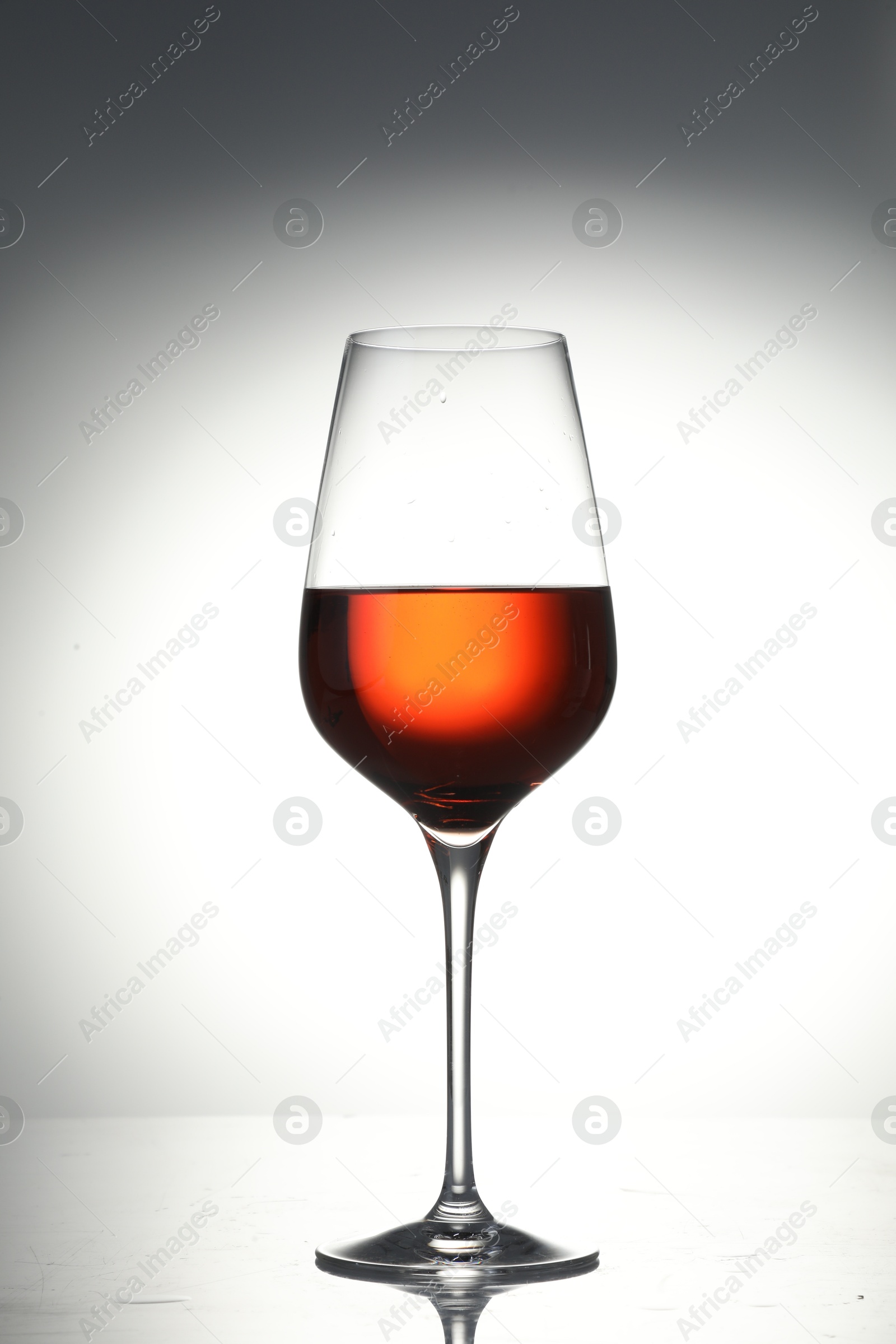 Photo of Tasty wine in glass on light background