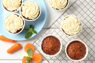 Photo of Delicious carrot muffins with fresh vegetables and mint on white wooden table, flat lay