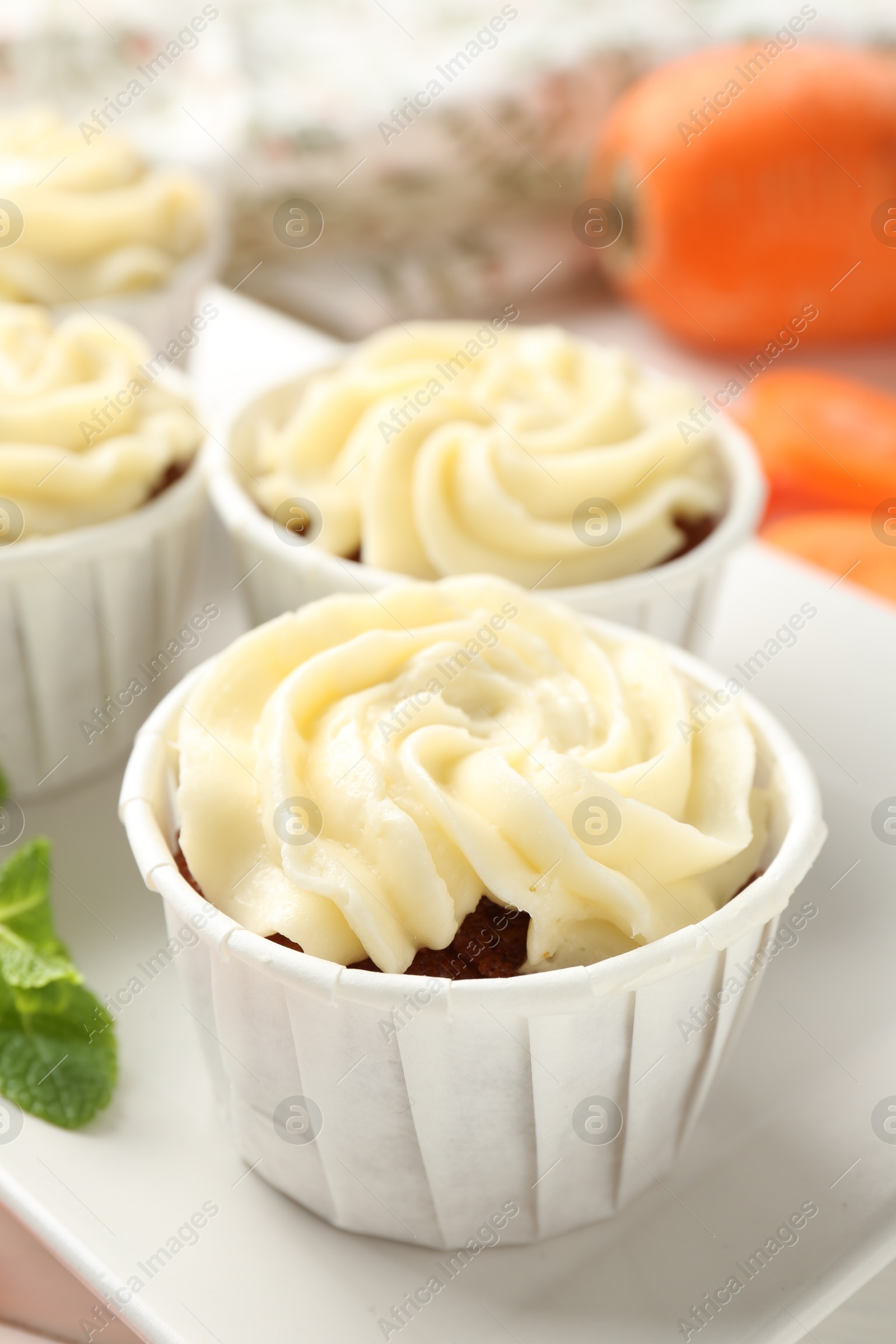 Photo of Tasty carrot muffins on white table, closeup