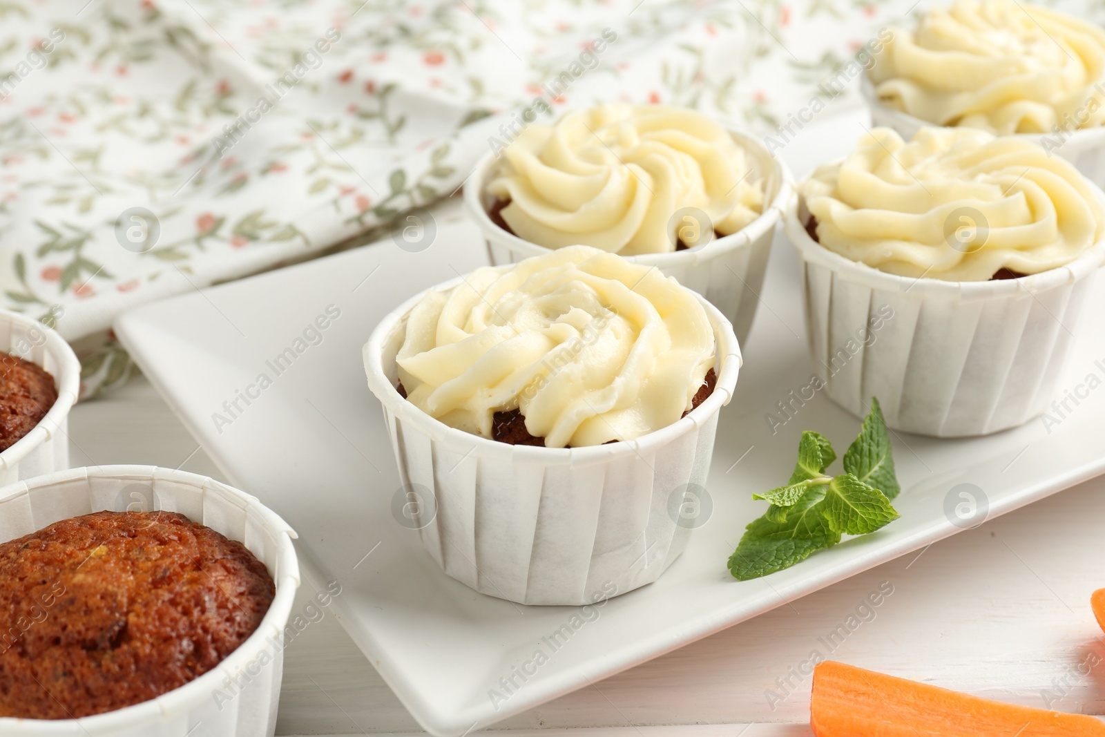 Photo of Tasty carrot muffins and mint on white wooden table, closeup