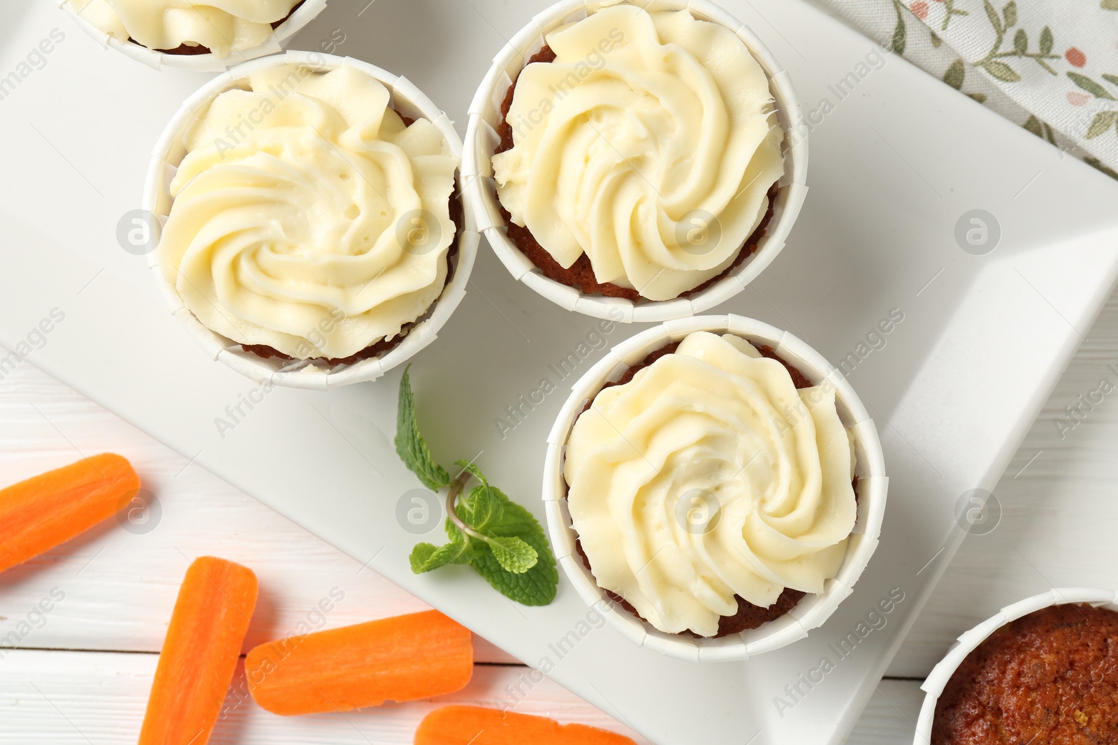 Photo of Delicious carrot muffins with fresh vegetables and mint on white wooden table, flat lay