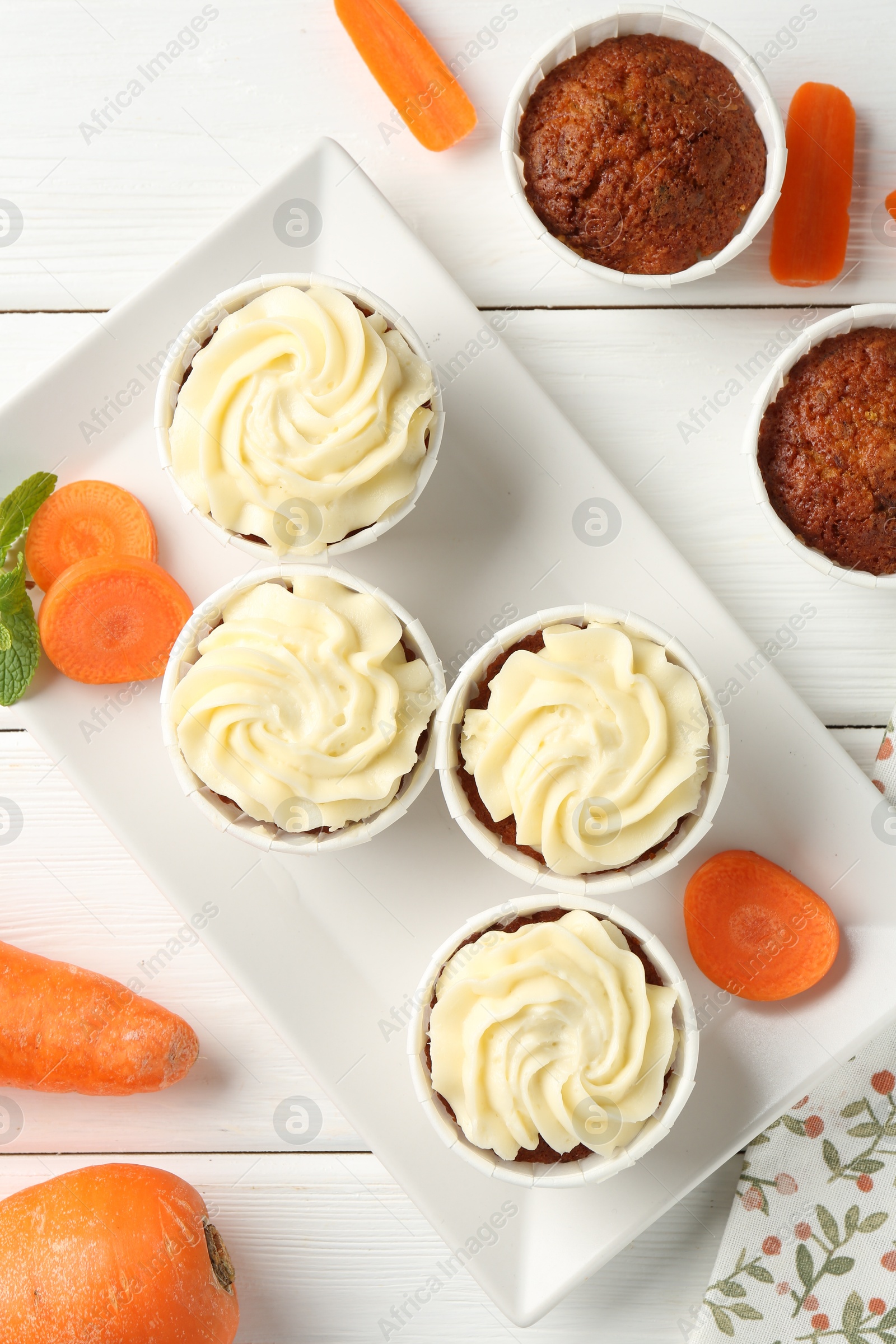 Photo of Delicious carrot muffins with fresh vegetables and mint on white wooden table, flat lay