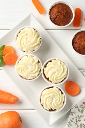 Photo of Delicious carrot muffins with fresh vegetables and mint on white wooden table, flat lay