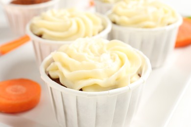 Photo of Tasty carrot muffins on white table, closeup