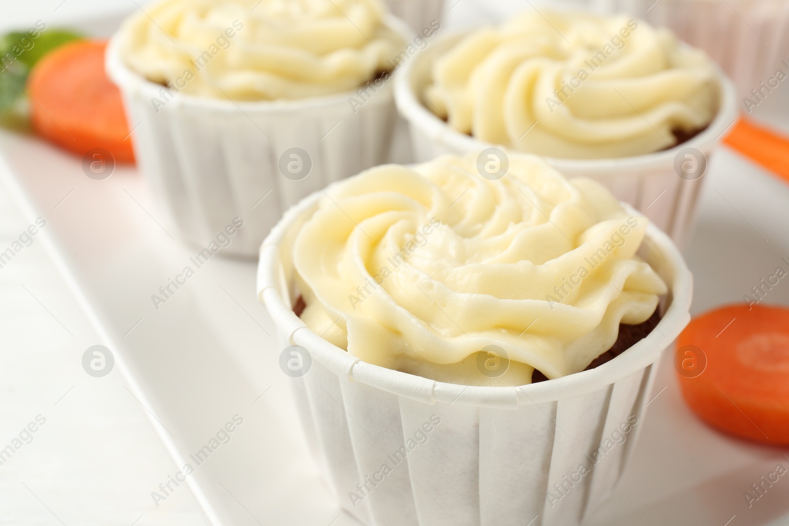 Photo of Tasty carrot muffins on white table, closeup