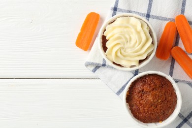 Photo of Tasty carrot muffins with fresh vegetables on white wooden table, flat lay. Space for text