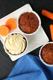 Photo of Tasty carrot muffins with fresh vegetables on grey table, flat lay