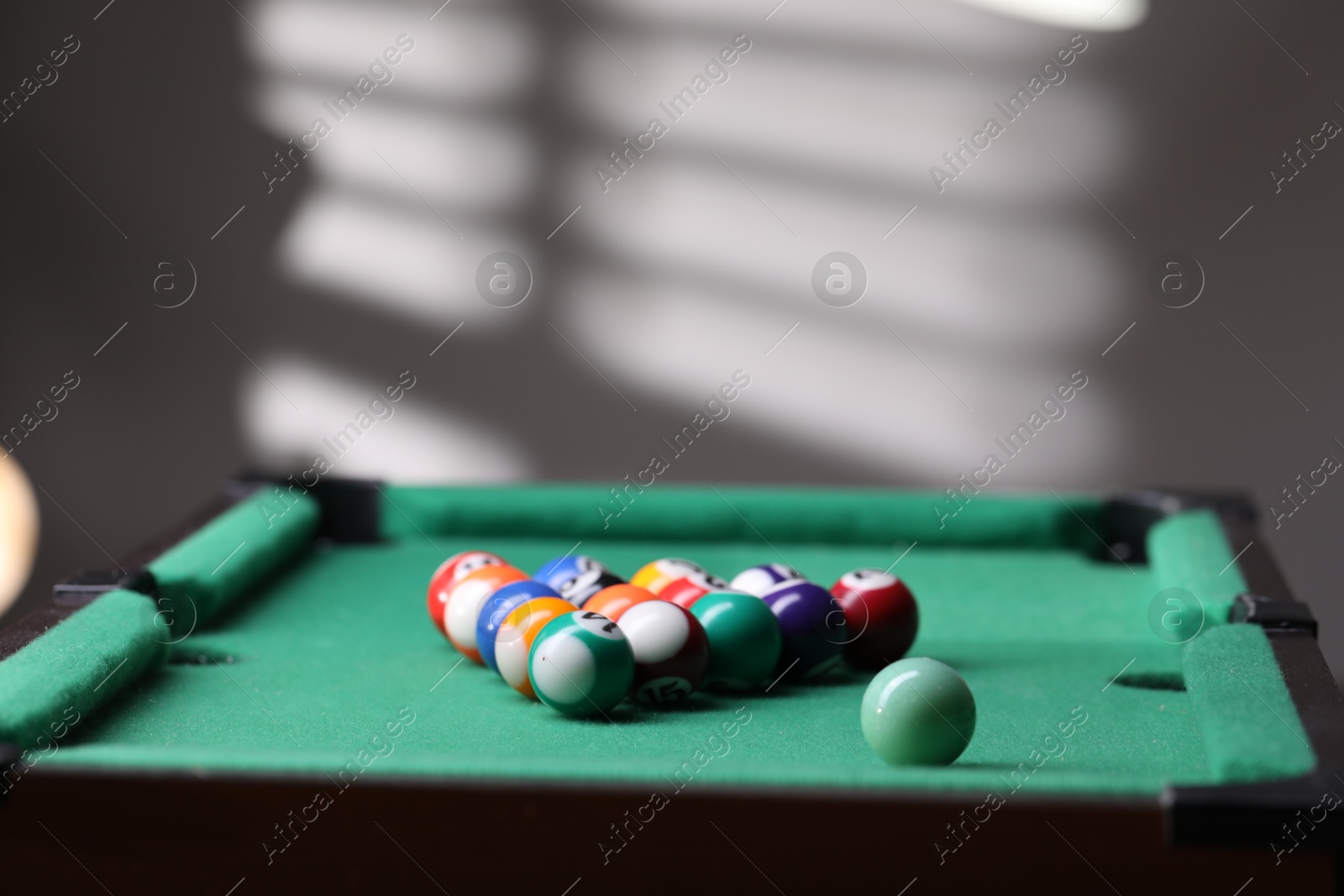 Photo of Billiard balls in triangle on green table indoors. Space for text