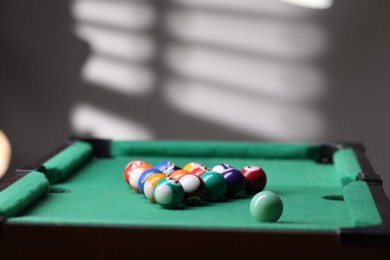 Photo of Billiard balls in triangle on green table indoors. Space for text