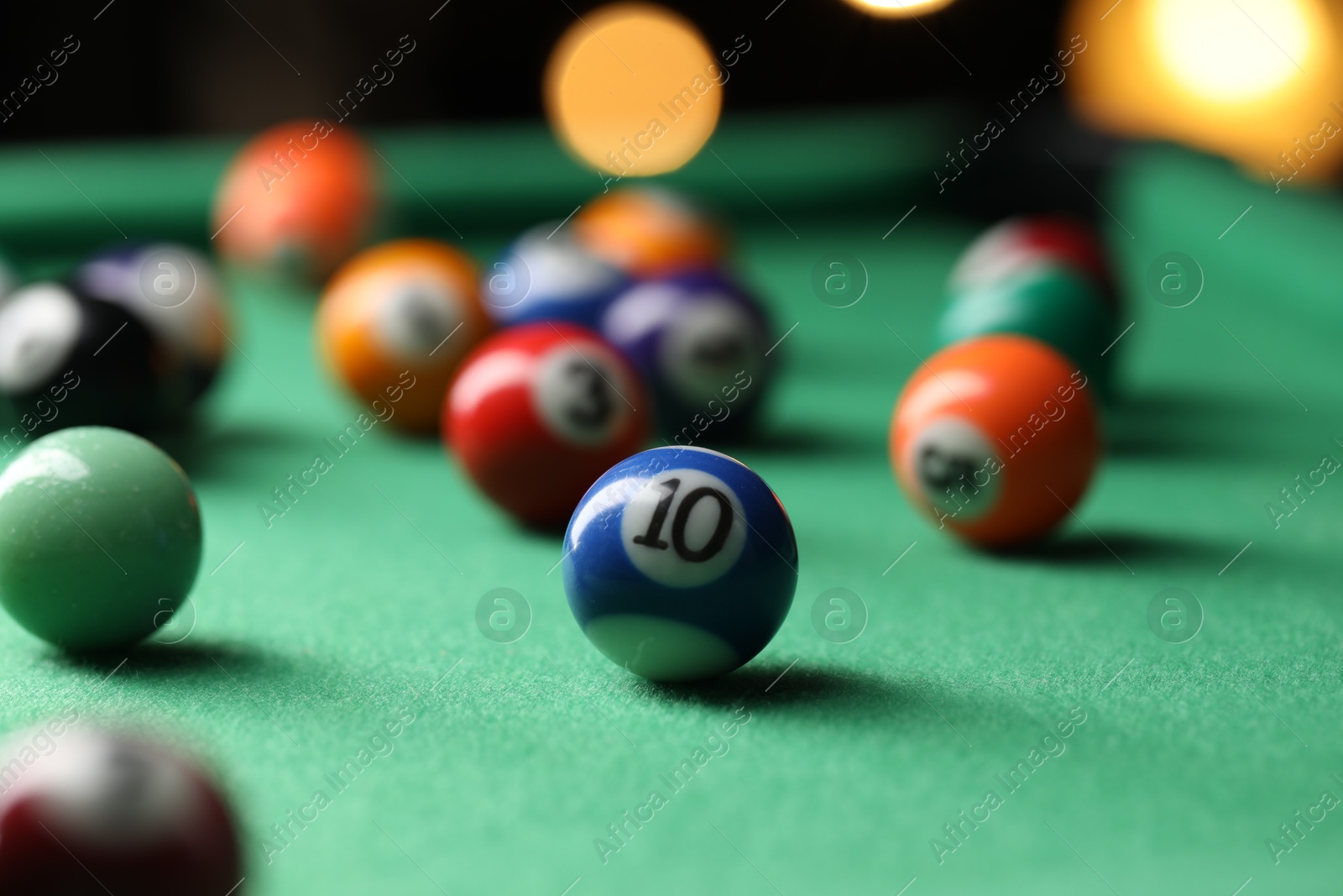 Photo of Many colorful billiard balls on green table indoors, closeup