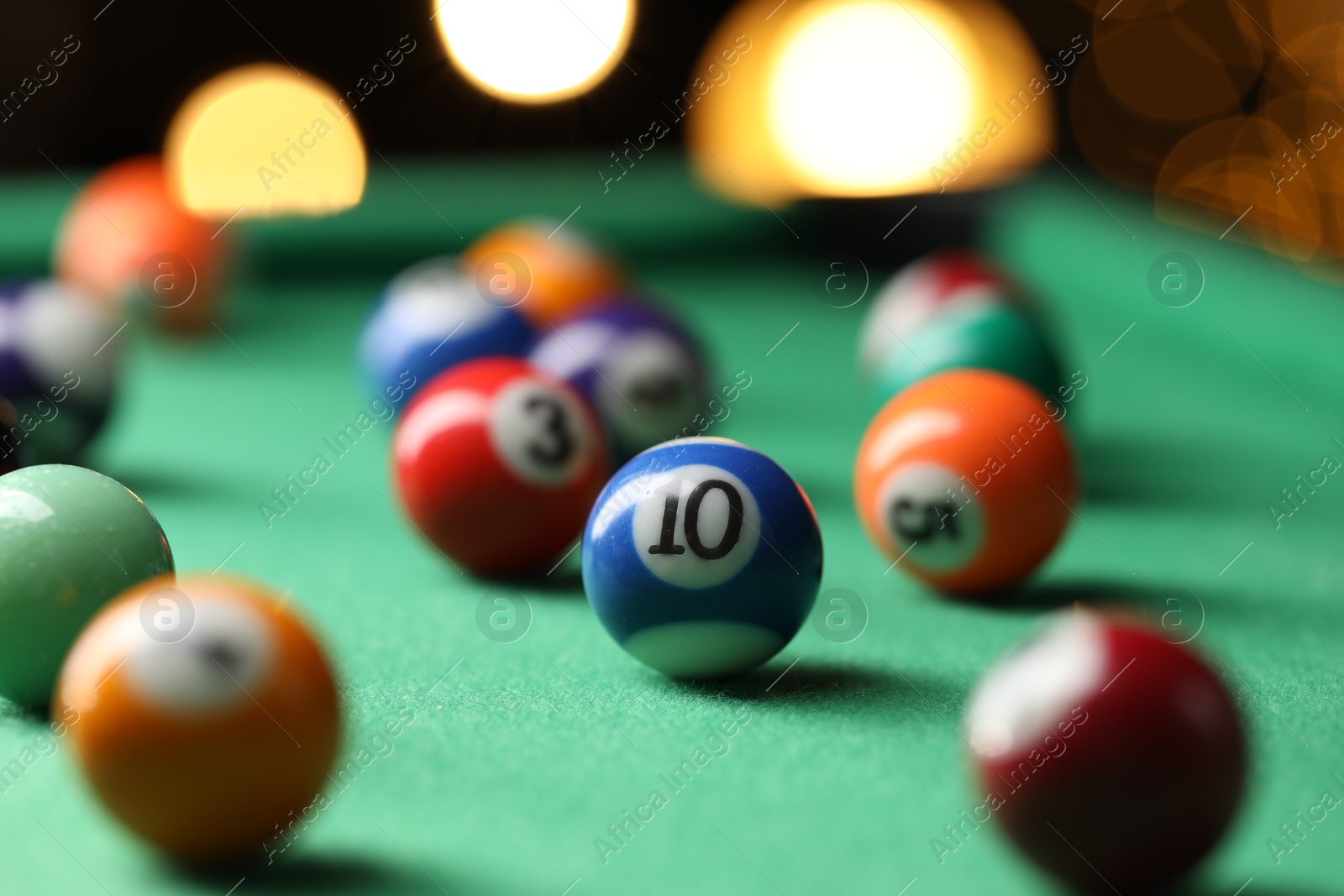 Photo of Many colorful billiard balls on green table indoors, closeup