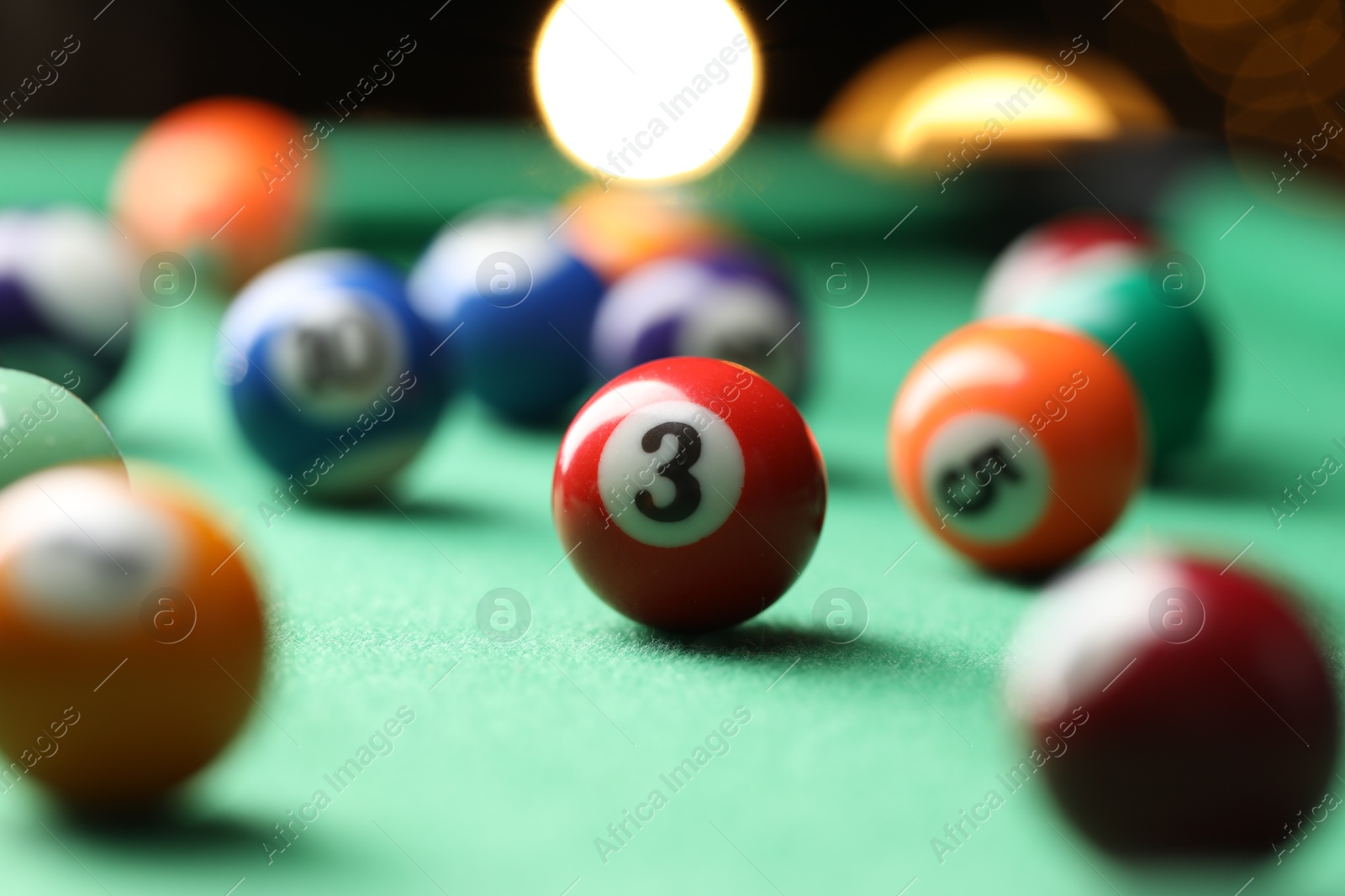 Photo of Many colorful billiard balls on green table indoors, closeup