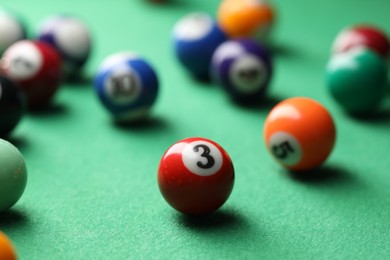 Photo of Many colorful billiard balls on green table, closeup