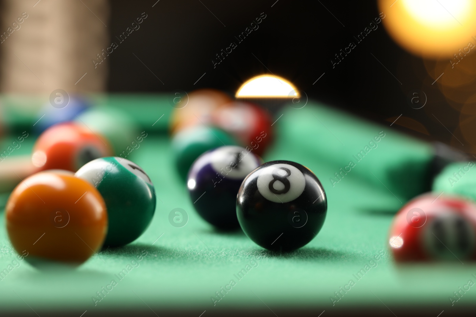 Photo of Many colorful billiard balls on green table indoors, closeup