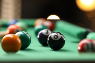 Photo of Many colorful billiard balls on green table indoors, closeup