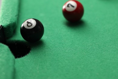 Photo of Billiard balls on green table, closeup. Space for text