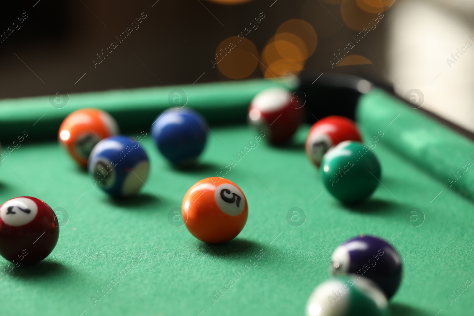 Photo of Many colorful billiard balls on green table indoors, closeup