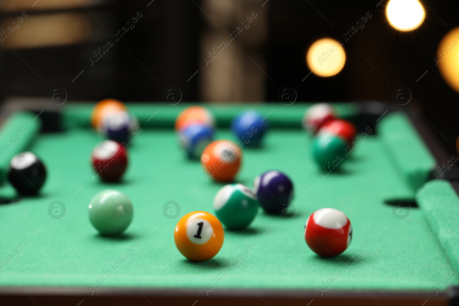 Photo of Many colorful billiard balls on green table indoors, closeup