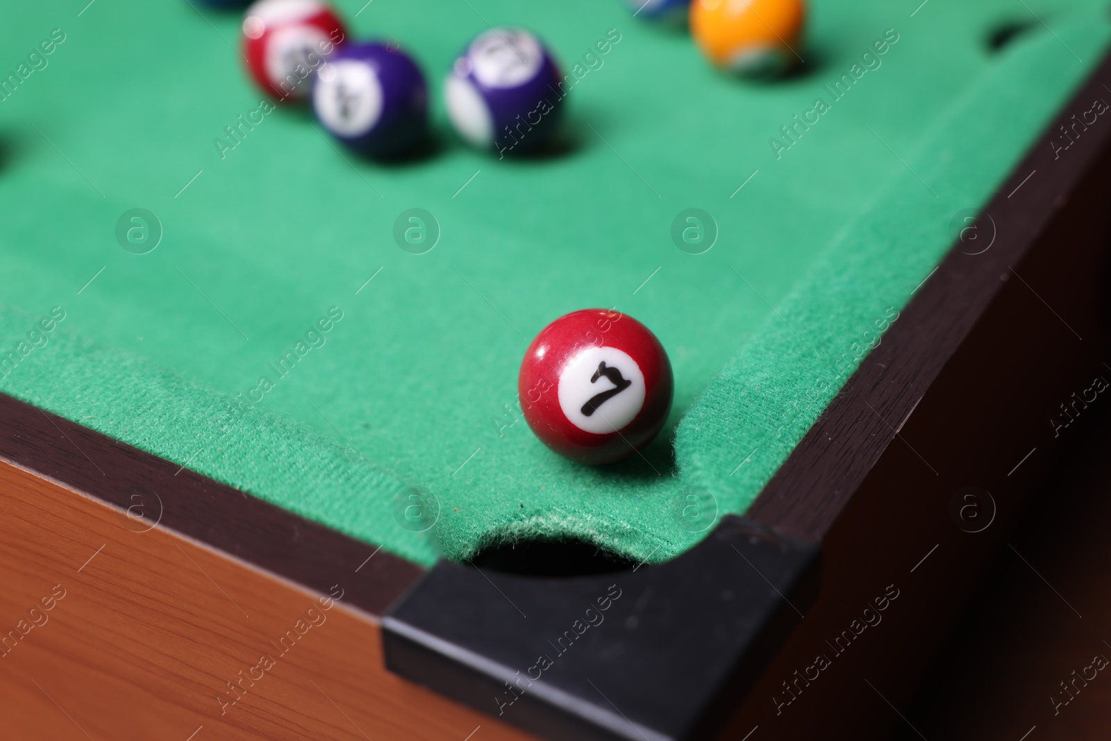 Photo of Many colorful billiard balls on green table, closeup