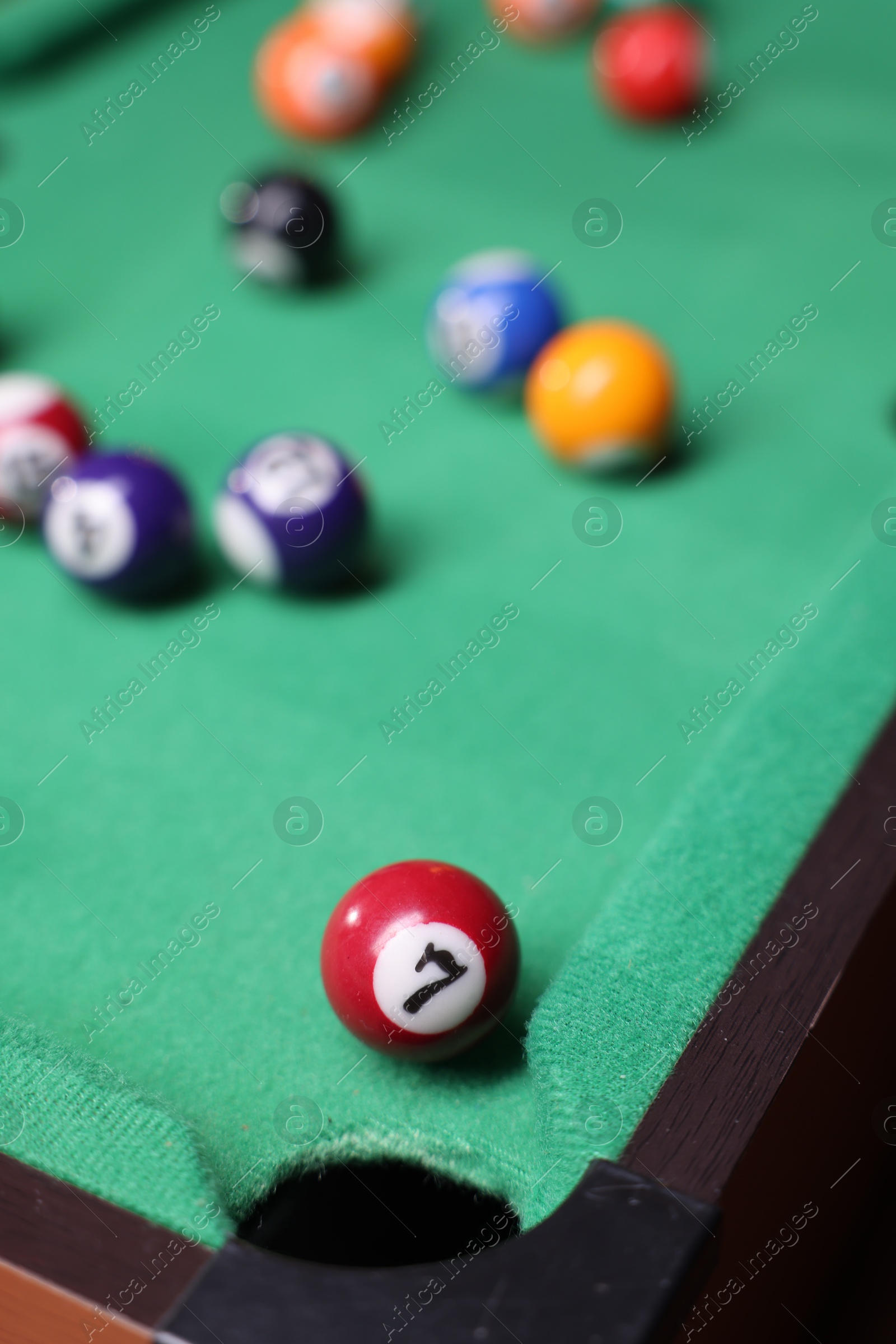 Photo of Many colorful billiard balls on green table, closeup