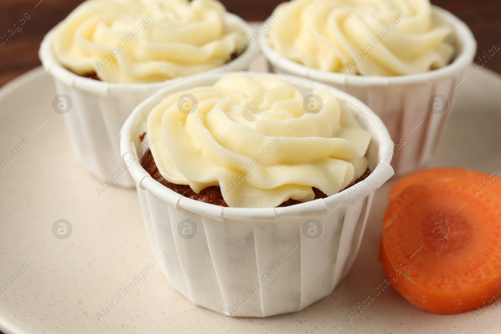 Photo of Delicious carrot muffins and fresh vegetable on table, closeup