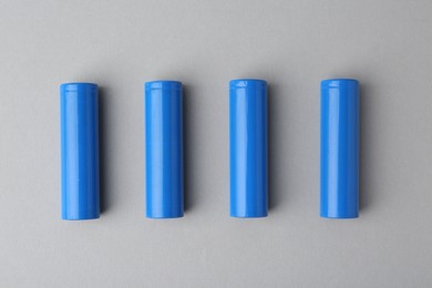 Photo of Many AA cell batteries on light grey background, top view