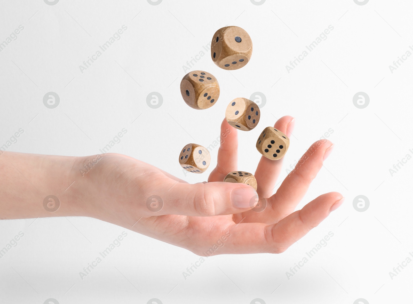 Image of Woman throwing wooden dice on white background, closeup