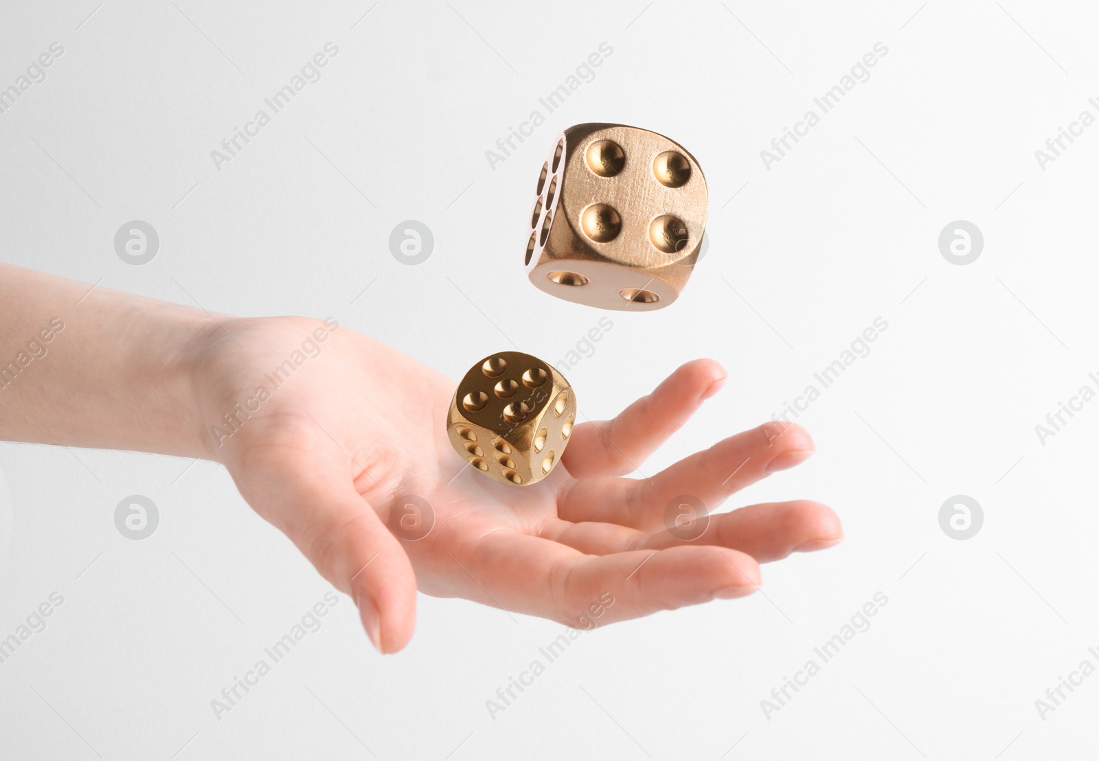 Image of Woman throwing gold dice on white background, closeup