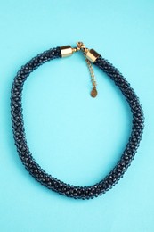 Photo of Beautiful bijouterie. Stylish bracelet on light blue background, top view