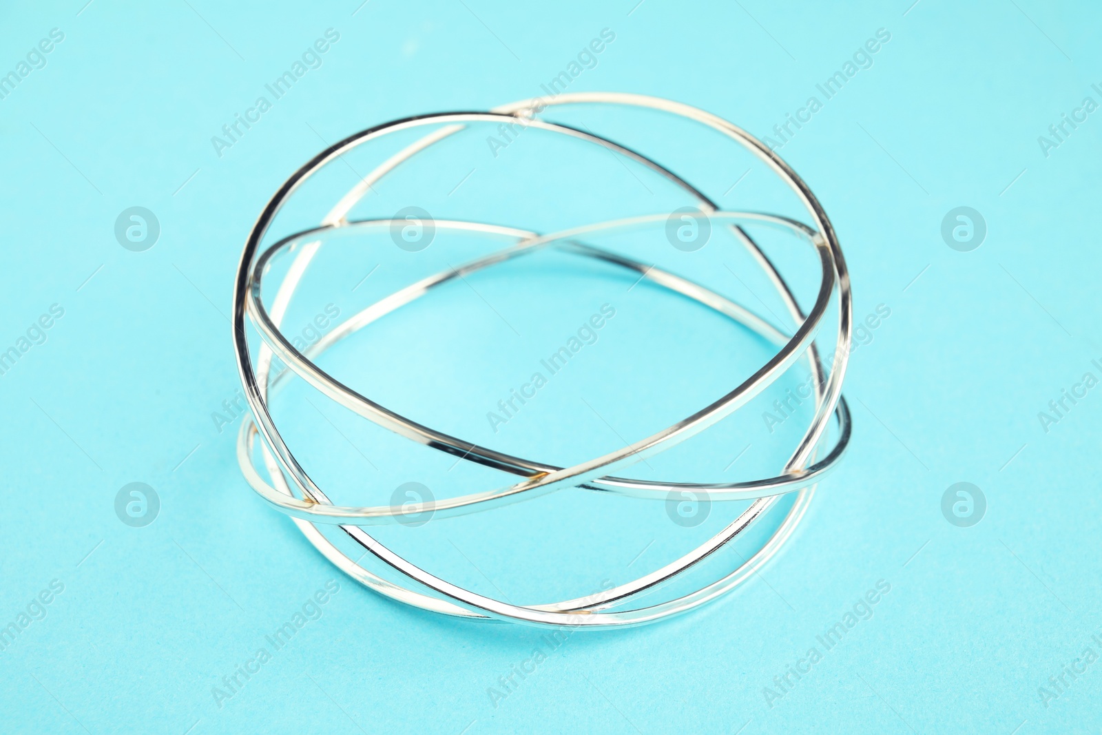 Photo of Beautiful bijouterie. Elegant bracelet on light blue background, closeup