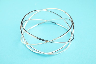 Photo of Beautiful bijouterie. Elegant bracelet on light blue background, closeup