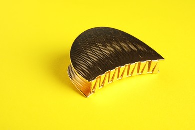 Photo of Beautiful bijouterie. Stylish hair clip on yellow background