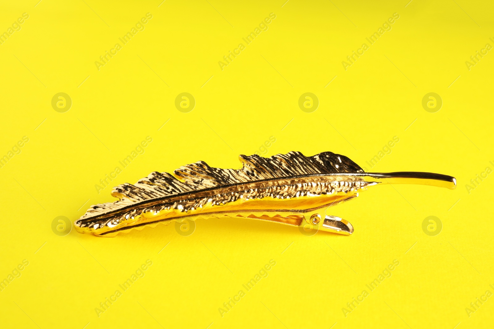 Photo of Beautiful bijouterie. Stylish hair clip on yellow background