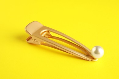 Photo of Beautiful bijouterie. Stylish hair clip on yellow background