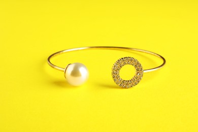 Photo of Beautiful bijouterie. Stylish bracelet on yellow background, closeup