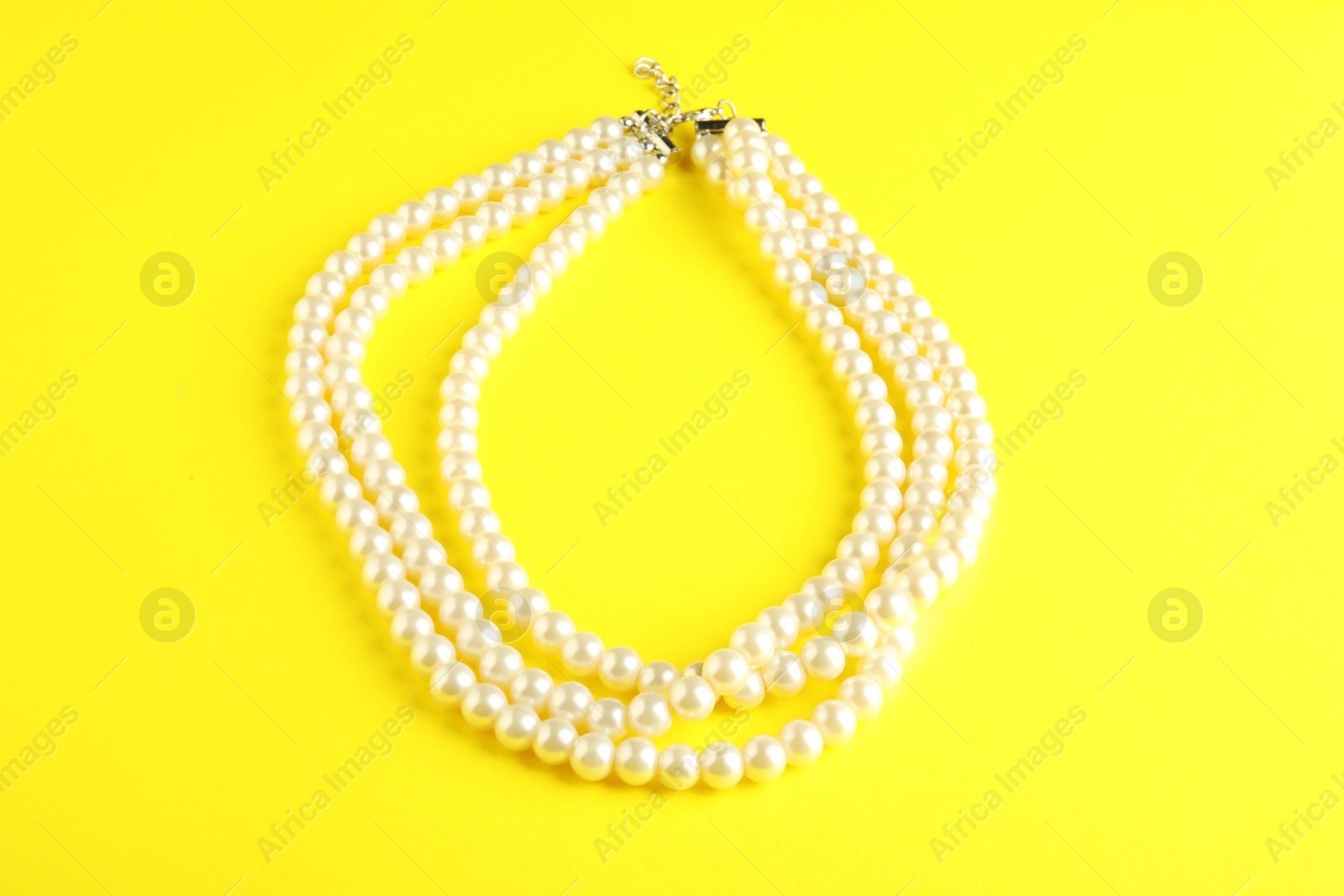 Photo of Beautiful bijouterie. Stylish necklace on yellow background